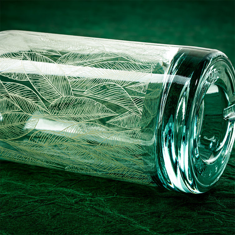 Screen Printed Glass Bottle with Leaf Design by Calaso Close-up of an screen printed glass bottle with a delicate leaf pattern, highlighting sustainable and decorative packaging design.